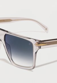 Διαφανή γυαλιά ηλίου με τετράγωνο σκελετό, με μπλε φακούς σε κλίμακα και χρυσές μεταλλικές λεπτομέρειες στα μπράτσα, σε λευκό φόντο.