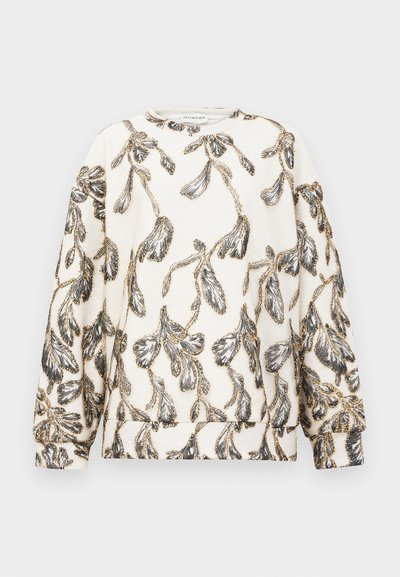 Kremna pulover s dolgimi rokavi, ki ima celovit črn in zlat vzorec listov in vejic ter okroglo ovratnico.