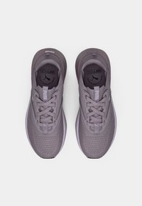 Pantofi sport violeți cu partea superioară texturată, vârf rotund, șireturi cu șase orificii și limbă moale și căptușită. Prezintă un logo pe limbă și pe laterale.