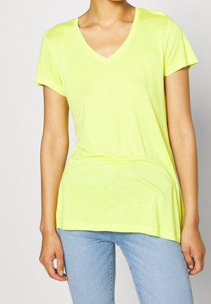 Camiseta de cuello en V de color amarillo neón con mangas cortas, hecha de tela suave. Presenta un corte relajado, una espalda ligeramente más larga y una textura suave.