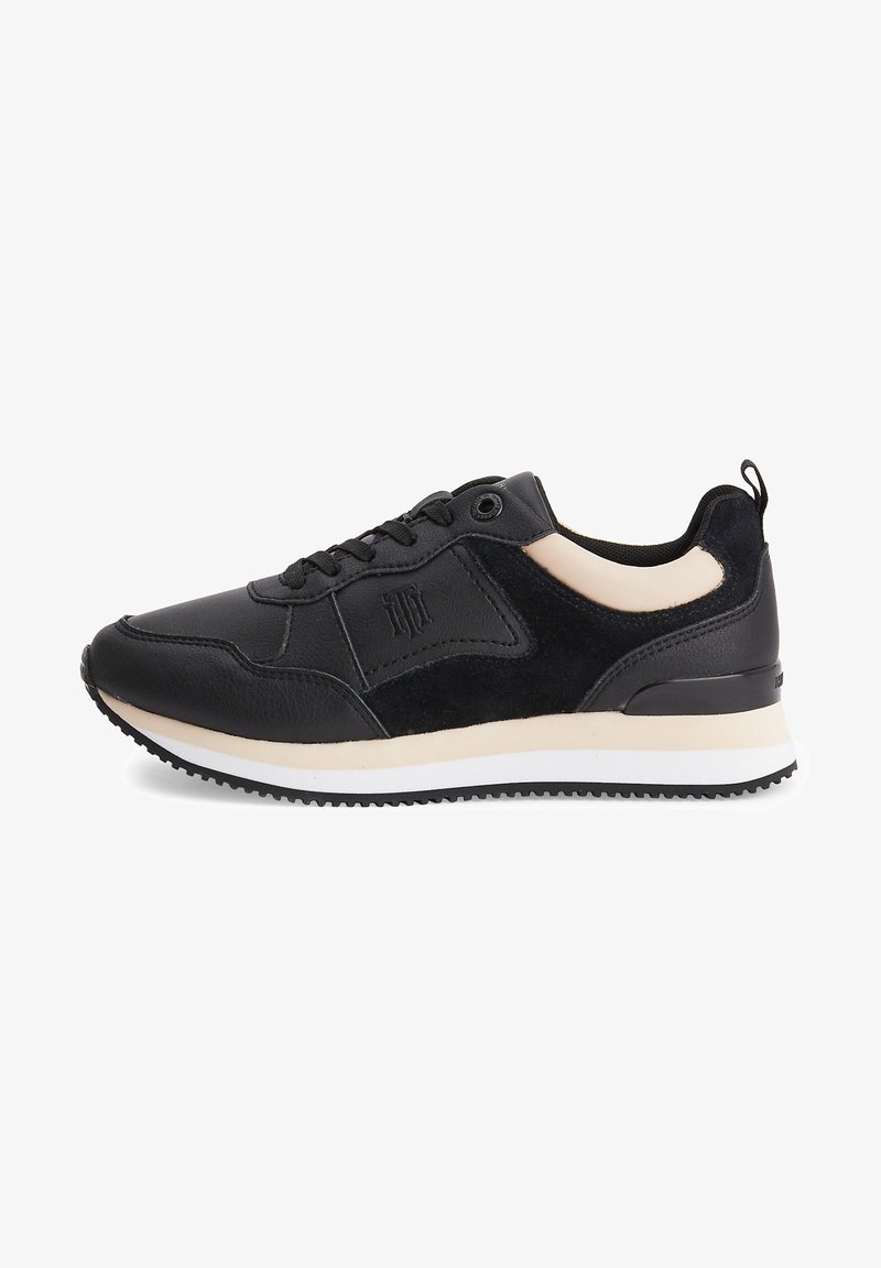 Chaussure de sport noire avec dessus en cuir et daim, accents crème, col rembourré, fermeture à lacets et semelle en caoutchouc texturée.