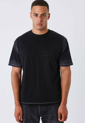 Zwarte katoenen t-shirt met een getextureerd hartslagontwerp op de borst, ronde hals en korte mouwen, met contrasterende stiksels.
