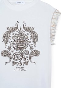T-shirt bianco con maniche corte e sfrangiate, caratterizzato da un dettagliato design floreale marrone e pavoni, con la scritta "SEGUI IL FLUSSO" in basso.