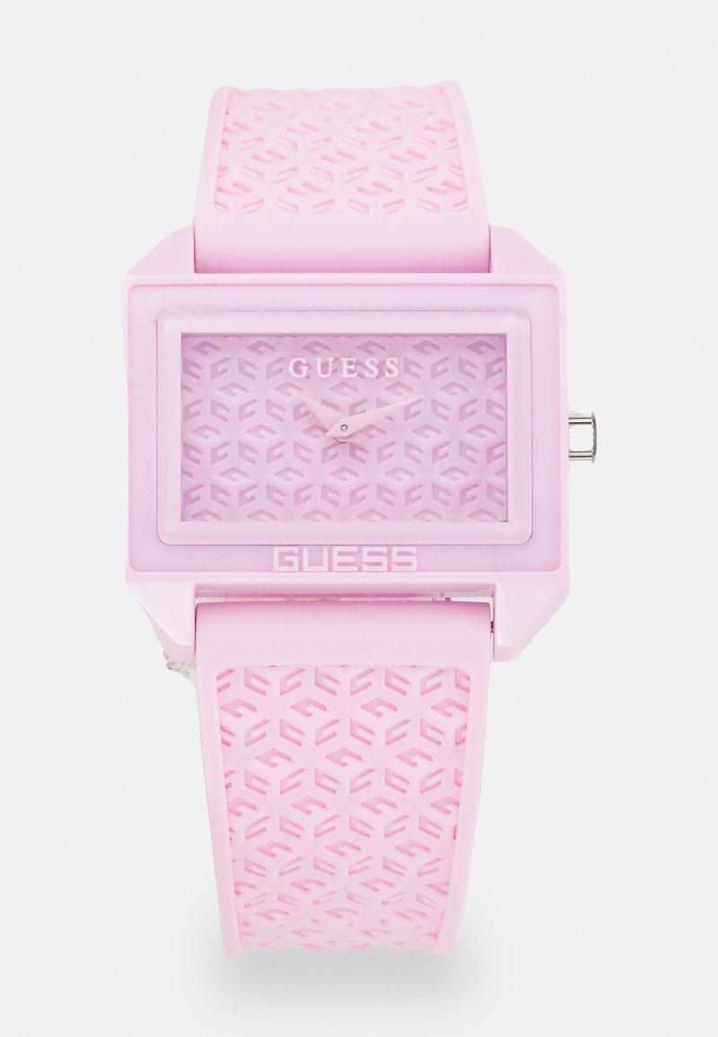Montre en silicone rose avec un cadran carré, bracelet texturé présentant un motif géométrique, et un cadran minimaliste avec des aiguilles et un logo argentés.