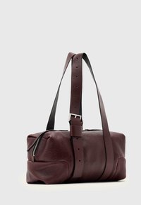 Burgundy leather duffel bag with a rectangular shape, featuring a top zipper, adjustable black straps, and a smooth, textured finish.