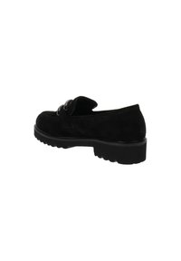 Scarpa slip-on in suede nero con punta arrotondata, fascia decorativa con dettagli metallici e suola in gomma nera robusta.