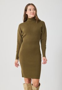 Sukienka w kolorze oliwkowym, dzianinowa, prążkowana, z wysokim kołnierzem, długimi rękawami i dopasowanym krojem. Miękka tekstura z wyraźnym detalem w talii.