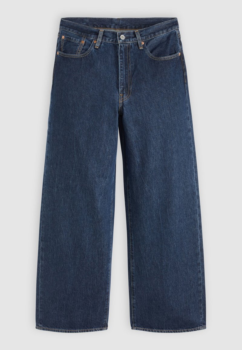 Jean en denim bleu foncé à jambes larges avec poches avant, fermeture à boutons et passants de ceinture, posé à plat sur un fond clair.
