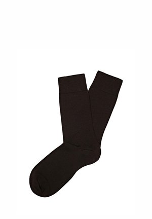Paire de chaussettes noires unies montantes avec bords côtelés, posées à plat sur un fond blanc.