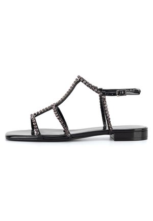Czarne sandały płaskie z połyskującym wykończeniem lakierowanym, wieloma paskami ozdobionymi małymi koralikami oraz regulowanym paskiem wokół kostki.