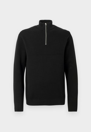 Sort strikket langærmet pullover med høj krave og halvmåne sølv lynlås på hvid baggrund.
