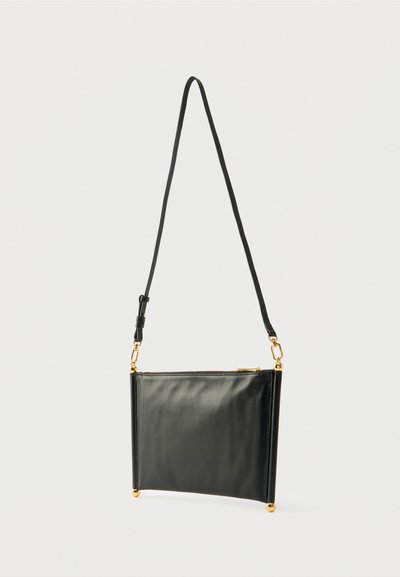Sac bandoulière en cuir noir avec un design rectangulaire élégant. Dispose d'une fermeture éclair et d'accents en métal doré. Texture lisse.