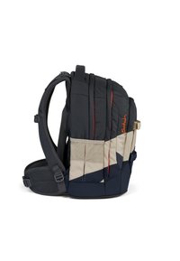 Rucksack mit einem schwarz-beigen geometrischen Design, ausgestattet mit gepolsterten Trägern, einem Mesh-Rücken und einem orangefarbenen Logo. Strapazierfähiger Stoff mit einer strukturierten Oberfläche.