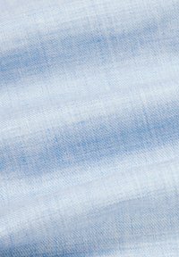 Jasnoniebieska tkanina dżinsowa o gładkiej fakturze, z subtelnym wzorem splotu i miękkim ułożeniem.