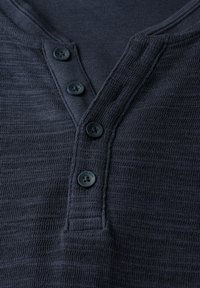 Navy blue henley shirt with a textured fabric, featuring a three-button placket and a rounded neckline. Smooth buttons and subtle stripes.