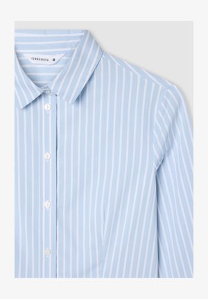 Jasnoniebieska koszula z guzikami z cienkimi białymi pionowymi paskami, klasycznym kołnierzykiem i gładką teksturą materiału. Etykieta marki widoczna wewnątrz kołnierza.