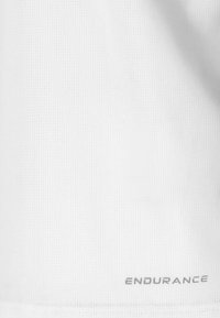 Tissu blanc texturé avec de petits trous répétitifs et le mot « ENDURANCE » imprimé en gris près du bord inférieur.