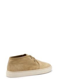 Scarpe alla caviglia in suede beige con punta arrotondata, chiusura minimale con lacci e suola in gomma testurizzata. Superficie superiore liscia, finitura morbida.