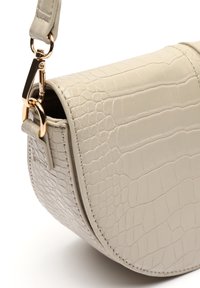 Borsa in pelle beige con texture coccodrillo, dotata di una chiusura in tono oro e cuciture laterali, caratterizzata da una forma semicircolare e finitura liscia.