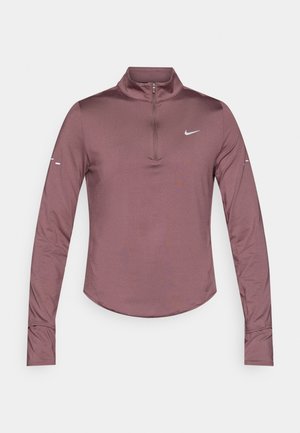 Pikkade varrukatega, lukuga kaelusega pluus tuhmunud mauve toonis. Valmistatud siledast, hingavast kangast, kitsas lõige ja Nike logo rinnal ning varrukatel.