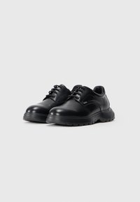 Chaussures en cuir noir avec une finition lisse, bout rond et fermeture à lacets ; conçues avec une semelle en caoutchouc épaisse pour plus de durabilité.