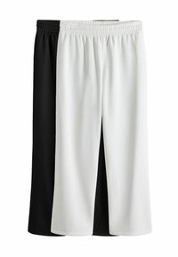 Pantaloni neri e bianchi, a lunghezza ginocchio, con una cintura elasticizzata. Tessuto morbido, texture liscia, con un design a colori divisi.