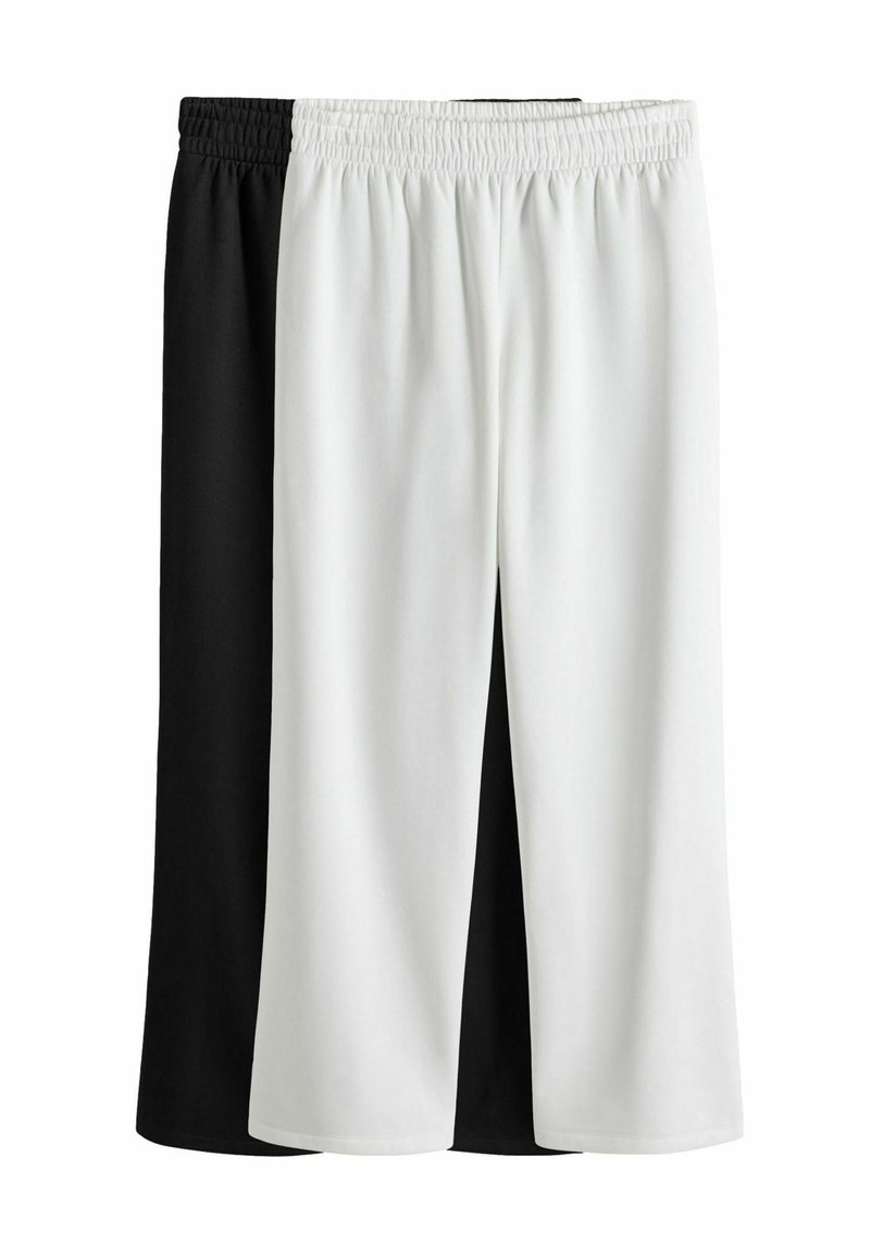 Pantaloni neri e bianchi, a lunghezza ginocchio, con una cintura elasticizzata. Tessuto morbido, texture liscia, con un design a colori divisi.