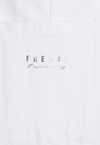 Tejido blanco con un logo plateado que lleva el texto "FREDDY training" en una fuente serif en negrita y un script cursivo debajo. Textura suave.