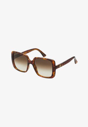 Tortoiseshell sunglasses with oversized square frames, gradient lenses, and subtle gold hardware accent on the temples.