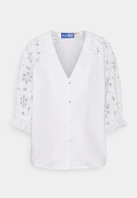 Blusa bianca con scollatura a V profonda e chiusura con bottoni. Presenta elaborati maniche a sbuffo in pizzo e dettagli di colletto ondulato.