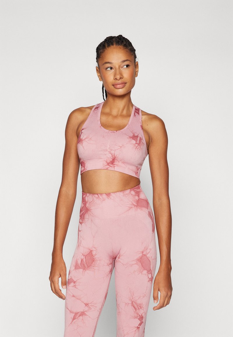 Lys rosa trenings-BH og høyhuset leggings med marmor mønster. Laget av elastisk stoff, med racerback-design og glatt tekstur.