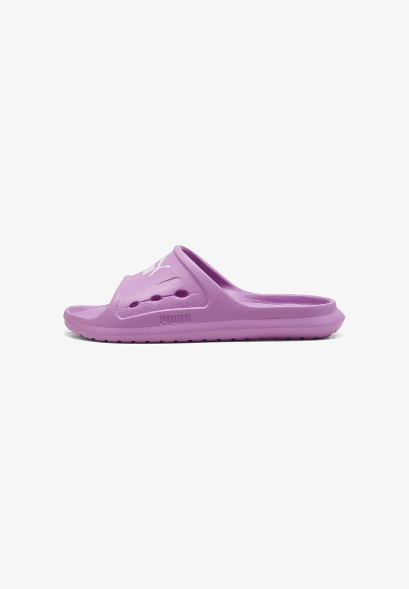 Sandale slide Puma violette avec des trous de ventilation, une semelle texturée et un logo Puma blanc sur la bride, vue latérale sur fond blanc.