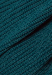 Türkisfarbener Strickstoff mit vertikaler Rippenstruktur, der feine Garne und eine glatte Oberfläche aufweist. Keine sichtbaren Muster oder Verzierungen.