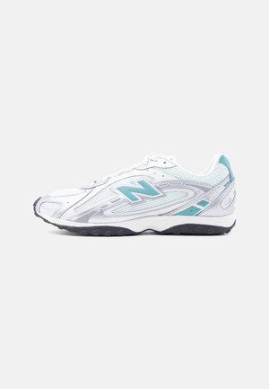 Biały i jasnoniebieski sneaker New Balance z siateczkowego materiału, logo na boku i czarną gumową podeszwą, pokazany z zewnętrznej strony.