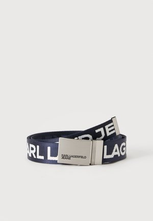 Cinturón de tela azul marino enrollado con texto blanco KARL LAGERFELD JEANS y hebilla metálica plateada grabada con el nombre de la marca sobre fondo liso.