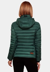 Jachetă puffer verde cu glugă, având o textură matlasată vertical și un etichetă de marcă maronie pe spatele inferior.