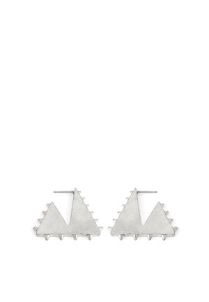 Boucles d'oreilles en métal argenté présentant deux formes triangulaires aux bords texturés et accents pointus, illustrant un design géométrique moderne.