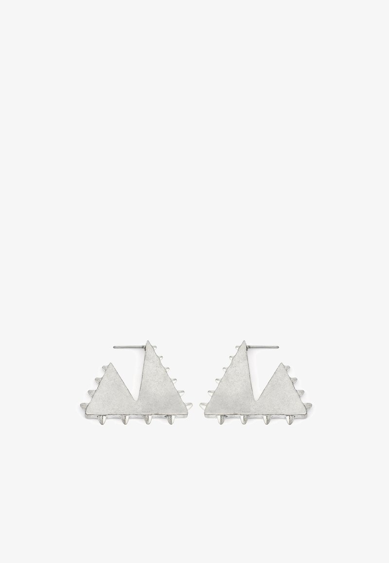 Boucles d'oreilles en métal argenté présentant deux formes triangulaires aux bords texturés et accents pointus, illustrant un design géométrique moderne.