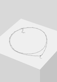 Collana d'argento a due strati, con anelli allungati e piccole perle rotonde, completa di un ciondolo circolare pendente.