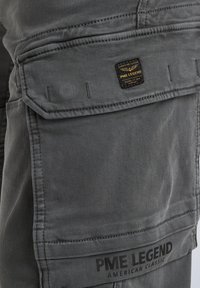 Graue Cargo-Hosen mit einer auffälligen Tasche und einem Markenlabel von PME Legend, gestickten Details und einer glatten, strapazierfähigen Stoffoberfläche.