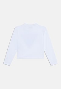 Weißes Langarm-Crop-Top aus einem weichen Stoff. Verfügt über einen runden Ausschnitt und ein innen im Kragen gedrucktes Etikett. Einfaches, minimalistisches Design.