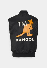 Colete preto sem mangas feito de cetim com um gráfico de canguru laranja e texto "TM KANGOL" nas costas. Cintura elástica na parte inferior.