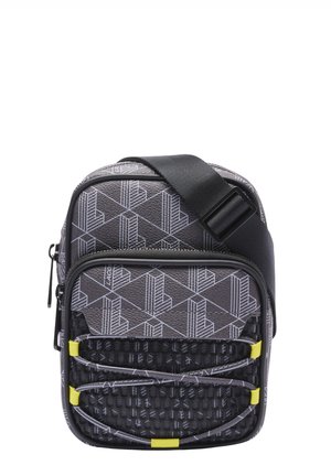 Compact gray crossbody bag with geometric patterns, front zip pocket, black textured panel, elastic cords, and adjustable black strap.