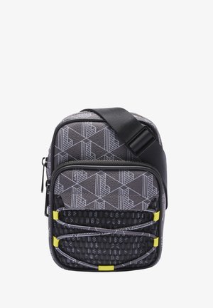 Sac bandoulière compact gris avec motifs géométriques, poche zippée avant, panneau texturé noir, cordons élastiques et sangle noire réglable.