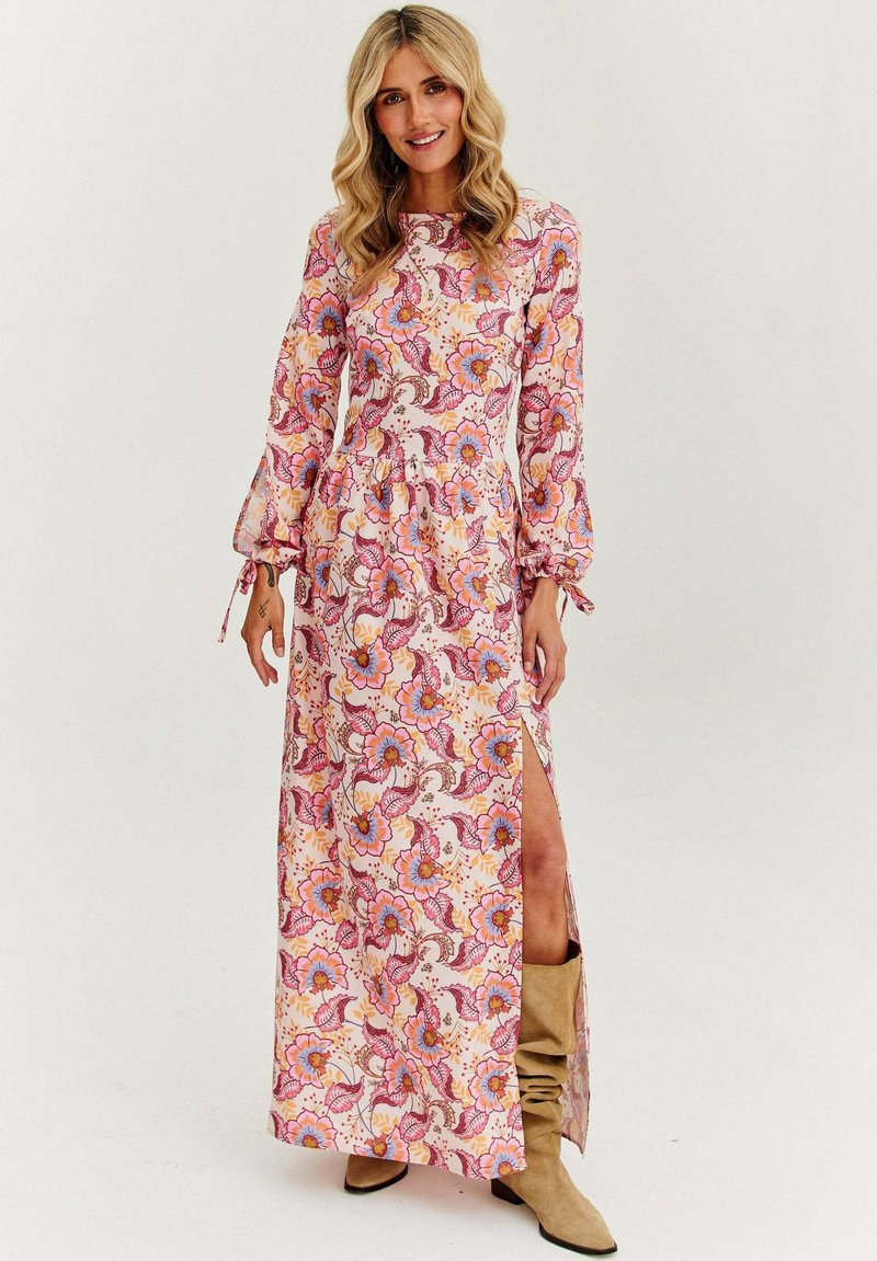 Maxi šaty s květinovým vzorem v růžové a oranžové barvě, dlouhými rukávy s rozšířenými manžetami a s bočním rozparkem. Vyrobené z lehkého materiálu.