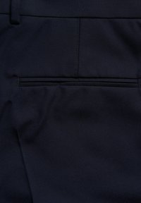 Marineblaues Hosen mit glatter Textur, versehen mit einer sich verschwinden lassenden Gesäßtasche und dezenten Nähdetails. Gefertigt aus einem robusten Stoff.