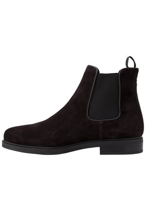 Bota Chelsea de ante negro con panel elástico lateral, talonera para facilitar el calzado y suela baja apilada.