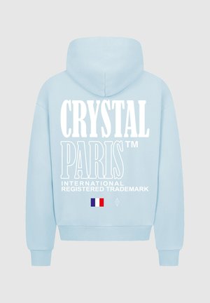 Lichtblauwe hoodie met een grote witte grafische tekst "CRYSTAL PARIS" op de rug, met Franse vlag en diamantlogo-details.