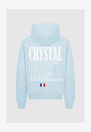 Lichtblauwe hoodie met een grote witte grafische tekst "CRYSTAL PARIS" op de rug, met Franse vlag en diamantlogo-details.
