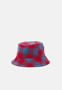 Červeno-modrá károvaná vedra čapica vyrobená z flanelového materiálu, s širokým okrajom a otvormi po stranách na ventiláciu.